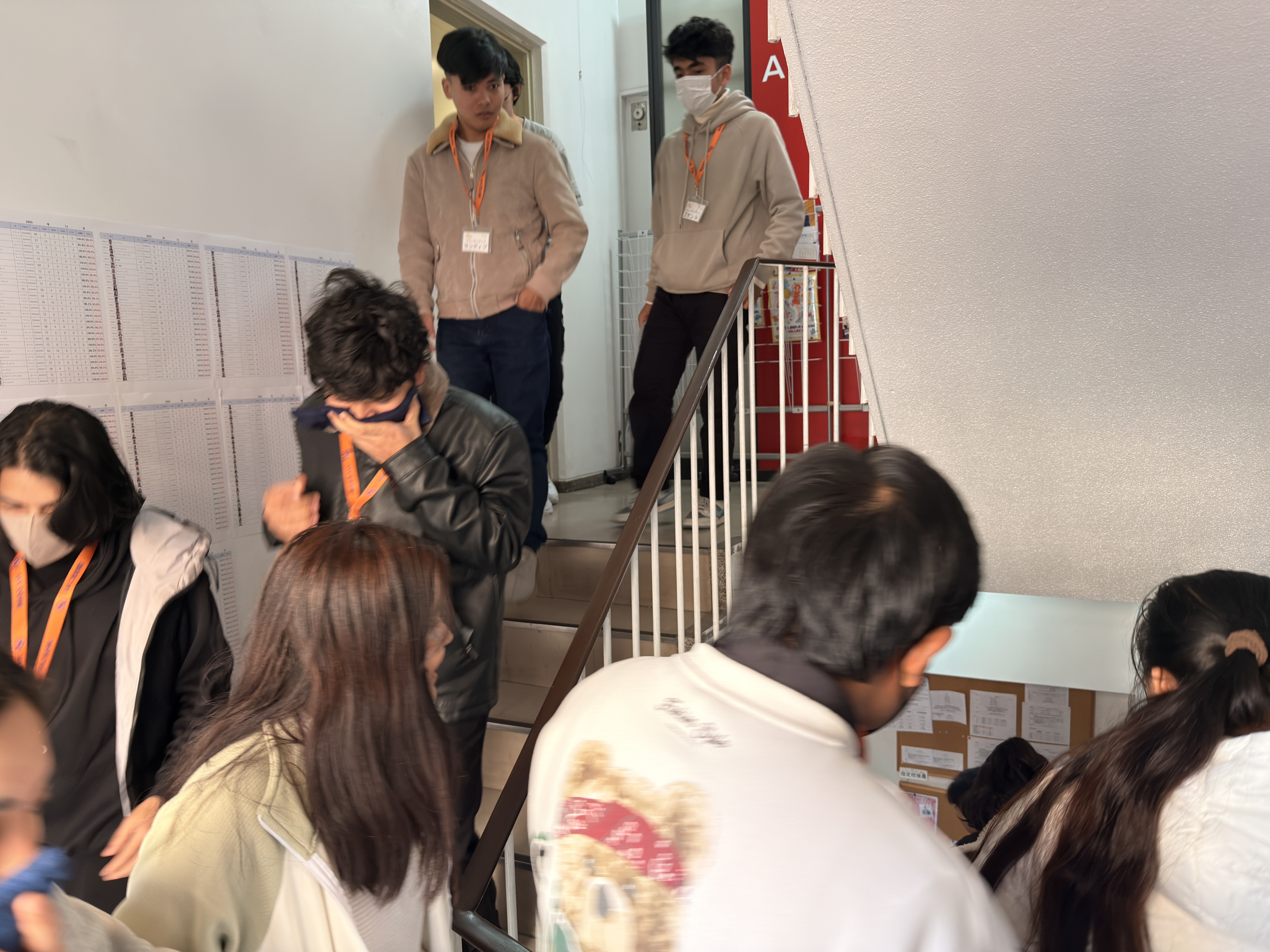 口元を覆い避難する生徒達