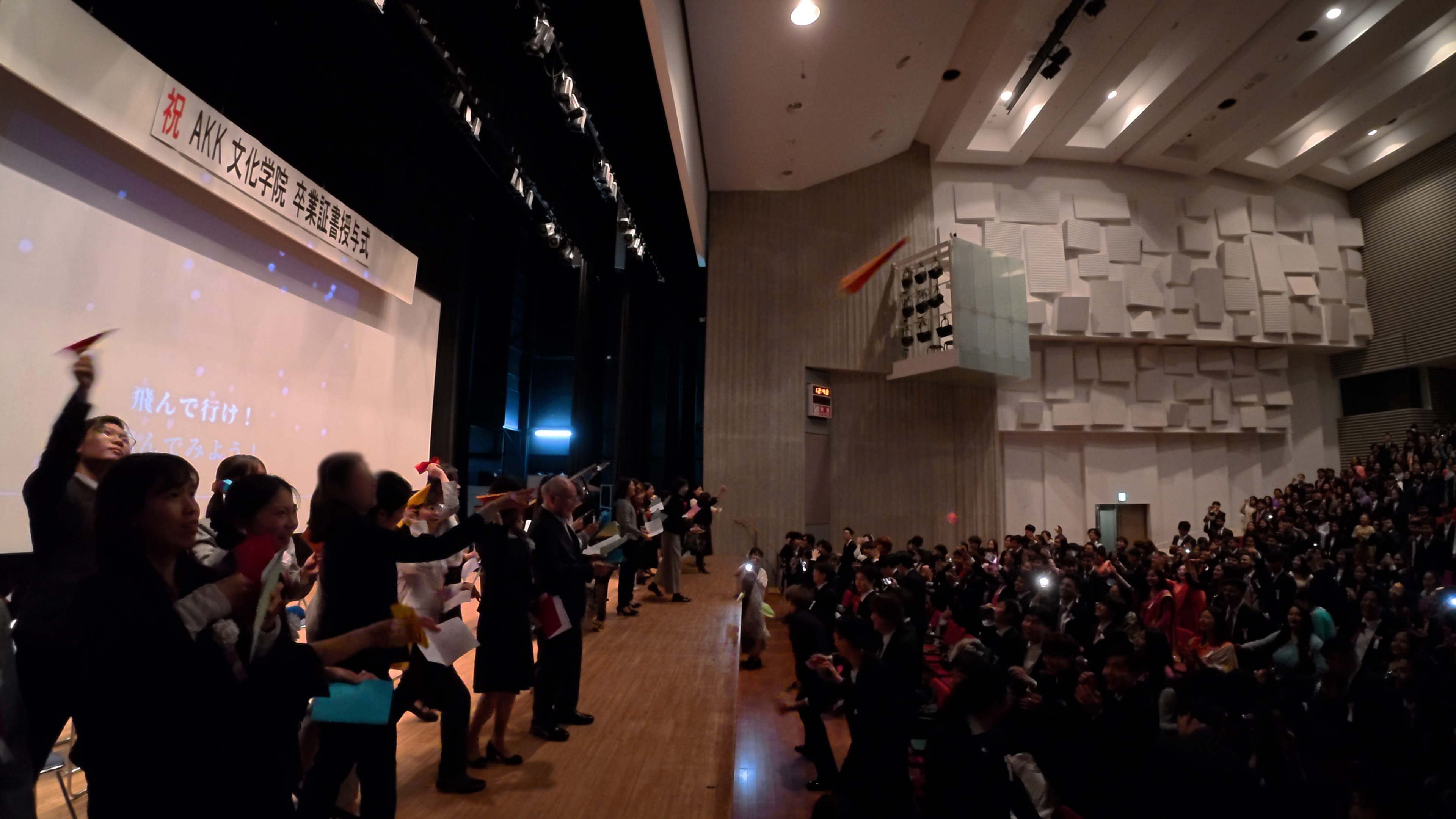 メッセージが書かれた紙飛行機を飛ばす先生たち